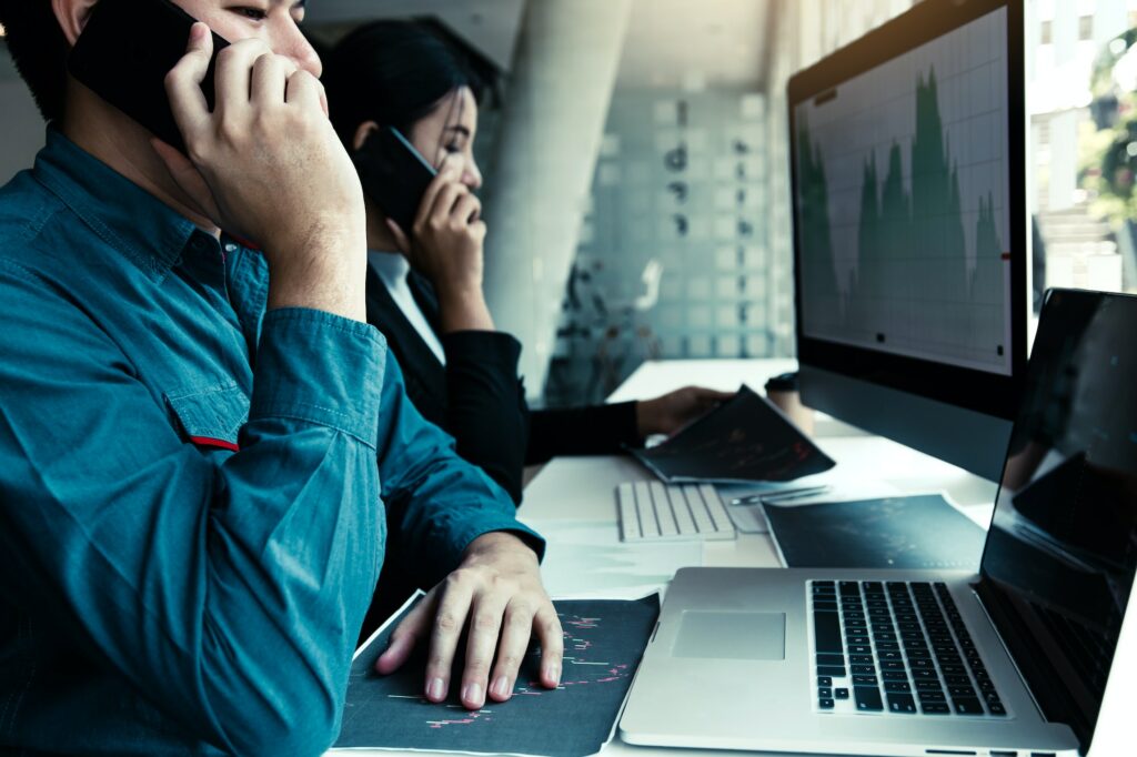 agent man working and analysis together in office market financial charts